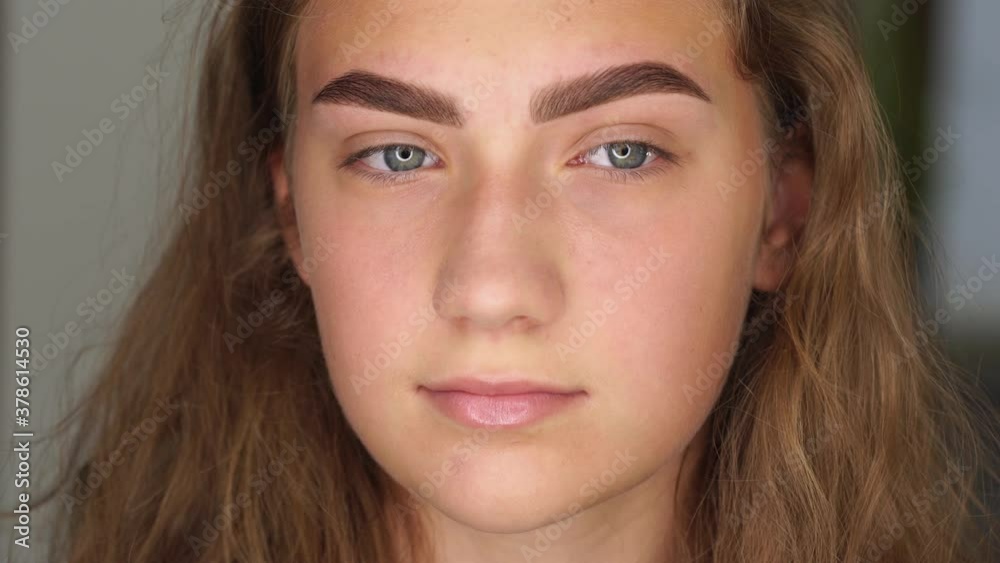 Professional styling, correction and lamination procedures of female eyebrows in beauty salon. Closeup view of young female client face after procedure. Professional styling, correction and lamination procedures of female eyebrows in beauty salon. Closeup view of young female client face after procedure.