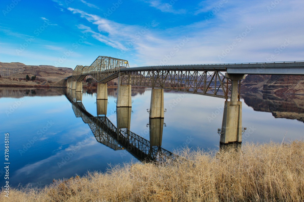 Fototapeta premium Reflection of bridge on calm river 