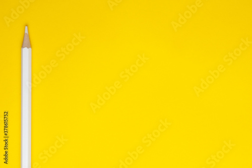 Horizontal white sharp wooden pencil on a bright yellow background, isolated, copy space, mock up.