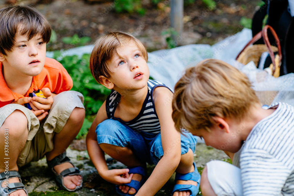 Fototapeta premium Two children boy working at backyard. Brother with gardening tools spending time, playing, create a cozy courtyard together outdoor at beautiful summer day. developmental activities for children