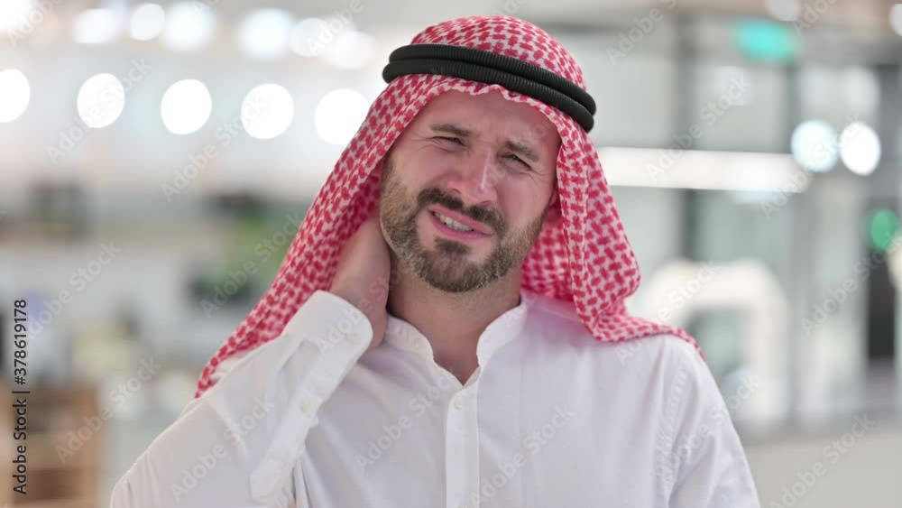 Stressed Arab Businessman having Neck Pain Stressed Arab Businessman having Neck Pain