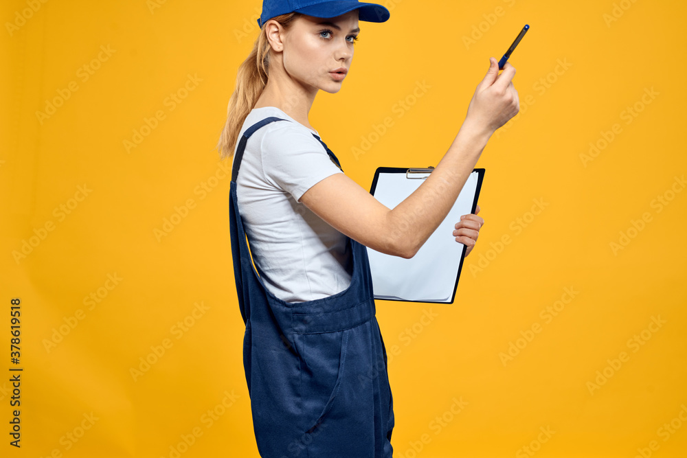 woman in work uniform documents courier service yellow background