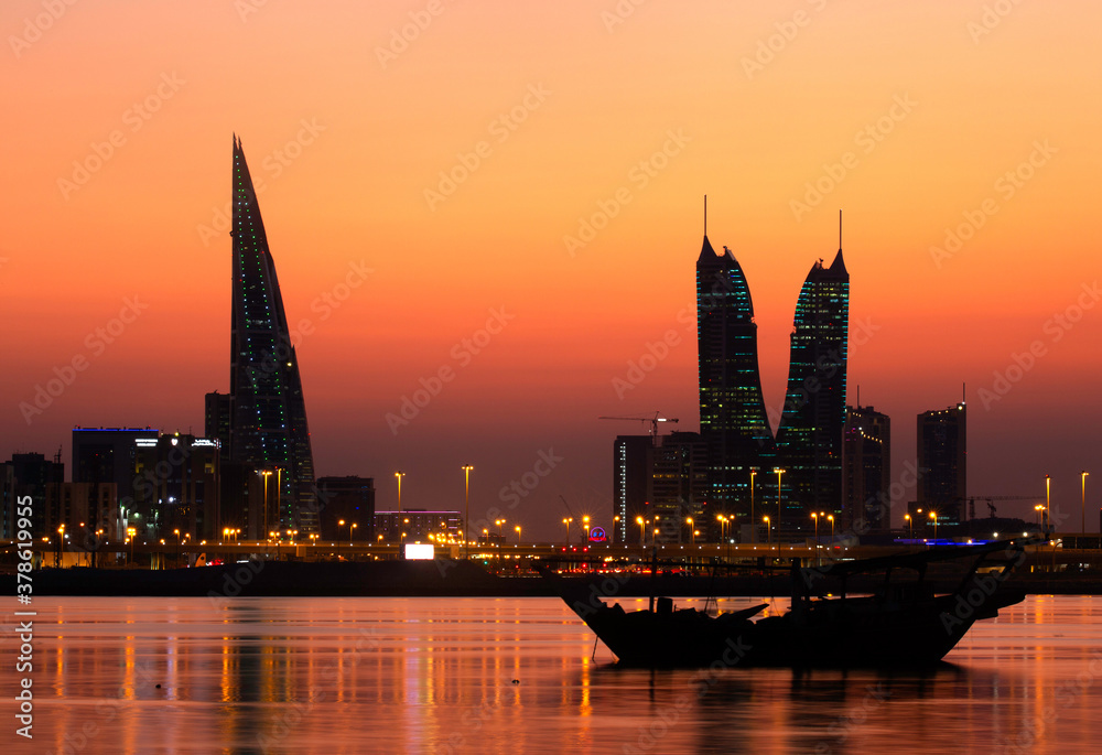 MANAMA , BAHRAIN - DECEMBER 02: Bahrain iconic towers and traditional boat with beautiful reflection during sunset on December 02, 2019, Bahrain