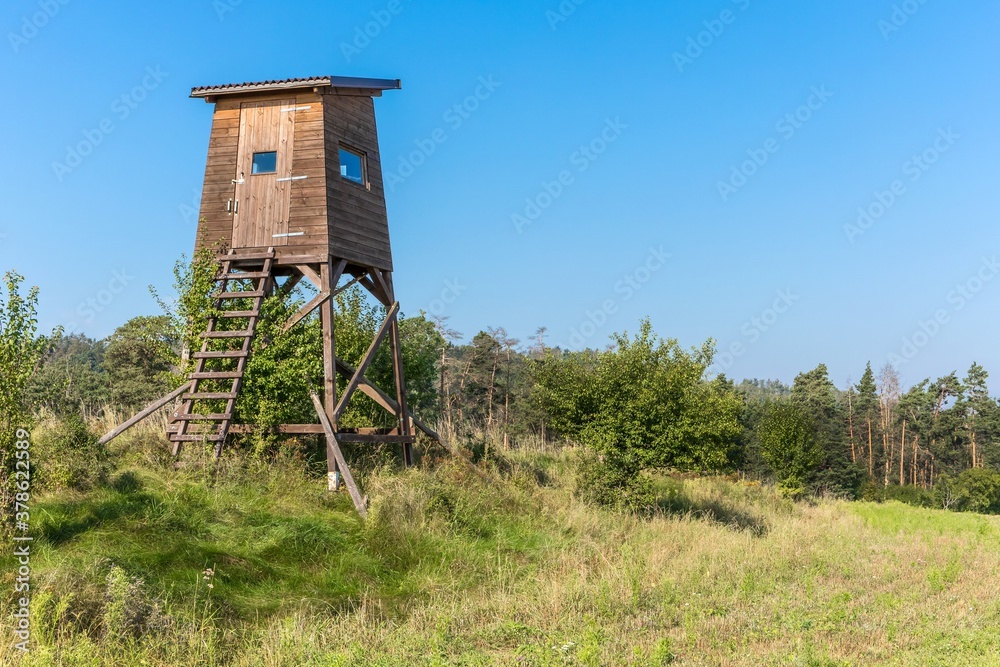 Hunting tower in nature,Czech Republic. Lookout tower for hunting in summer day. Agricultural landscape in the Czech Republic. A place for hunting wildlif Hunting tower in nature,Czech Republic. Lookout tower for hunting in summer day. Agricultural landscape in the Czech Republic. A place for hunting wildlif