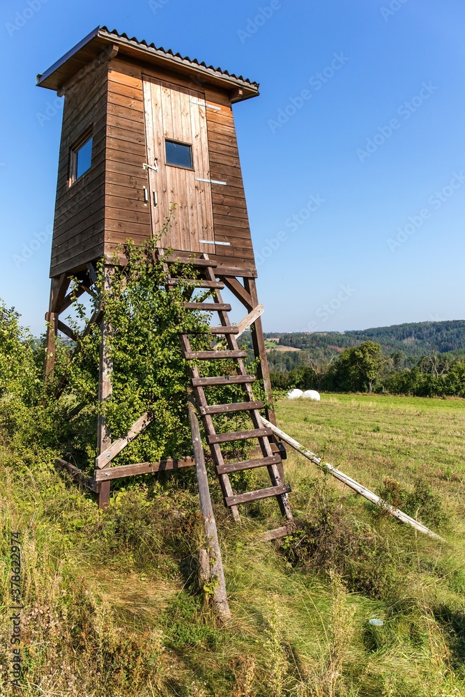 Hunting tower in nature,Czech Republic. Lookout tower for hunting in summer day. Agricultural landscape in the Czech Republic. A place for hunting wildlif