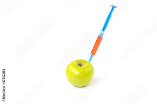 Green apple and syringe on a white background. Cosmetology, skin care and genetic modification concept