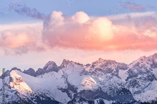 Fototapeta Naklejka Na Ścianę i Meble -  Sunset with dramatic sky and snowy mountain peaks illuminated by sunlight, Tatra Mountains in winter time. Mountain range in Bialka Tatrzanska, Poland