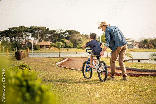 Avô ensinando neto andar de bicicleta