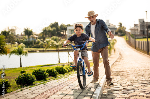 Avô ensinando neto andar de bicicleta