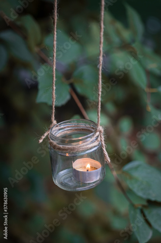 Homemade candle holder hanging on the tree branch, selective focus