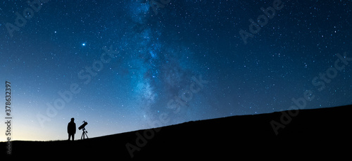 Foto Person observing the blue starry sky with a telescope at night