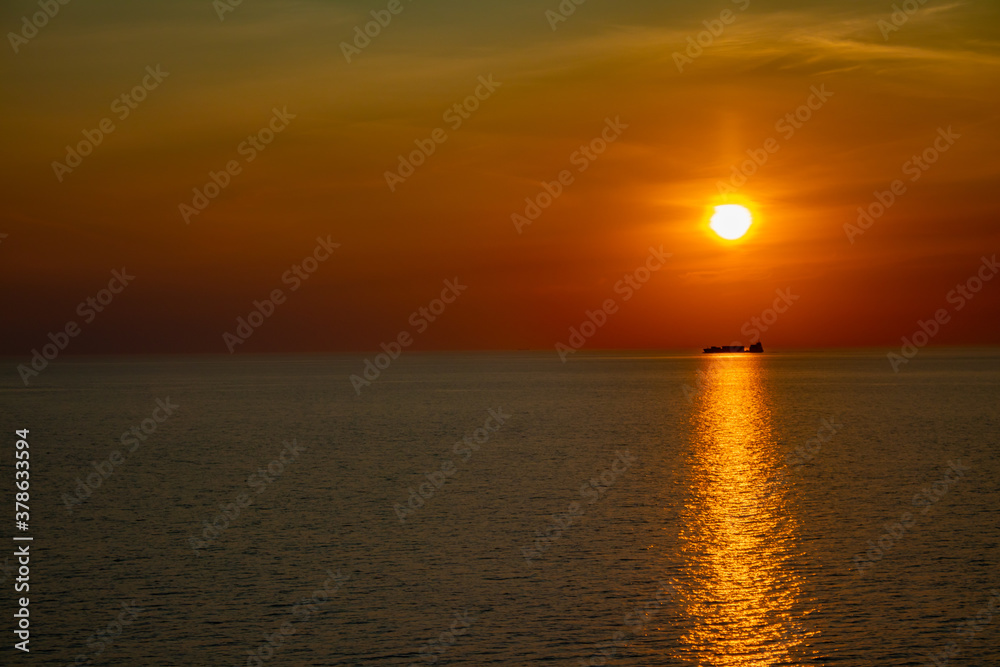 Fototapeta premium Sailing boat under the sun goes down