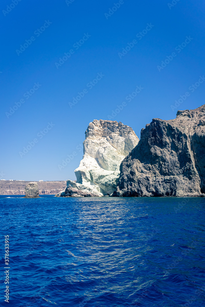 Face shaped rock on the blue sea against a blue sky. Akrotiri, santorini, cyclades, Greece