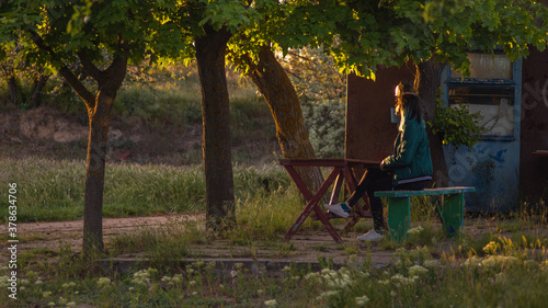 Young woman rest in old garden in sunset