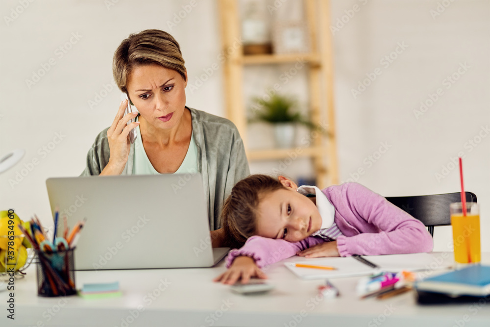 Busy mother working at home while her daughter is feeling bored. Busy mother working at home while her daughter is feeling bored.