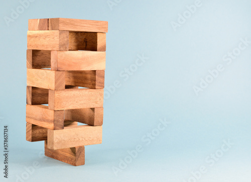 A corner view on a tower built from wooden blocks and placed on one block