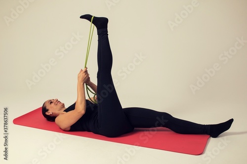 Obraz na płótnie fitness woman with elastic bands doing hamstring stretch