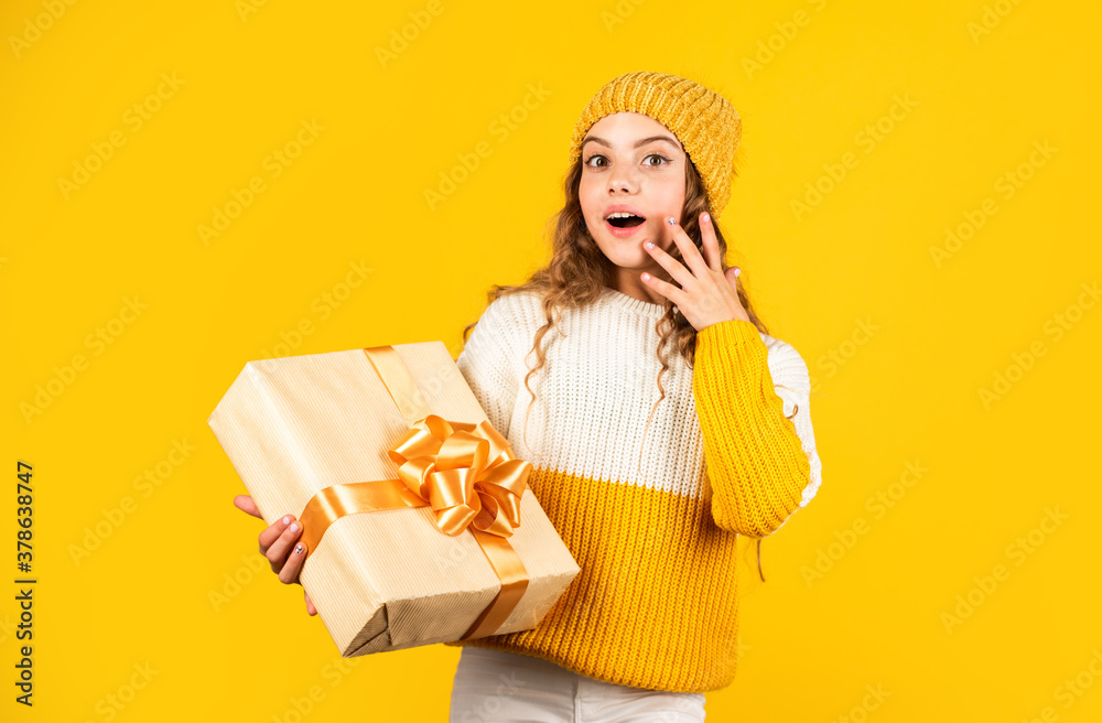 Kid little girl hold gift box with ribbon on yellow background. Teen girl received holiday gift. Best christmas gifts. Child excited unpacking gift. Christmas present for daughter. Enjoy surprises Kid little girl hold gift box with ribbon on yellow background. Teen girl received holiday gift. Best christmas gifts. Child excited unpacking gift. Christmas present for daughter. Enjoy surprises