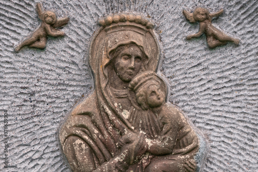 Virgin Maria with child on vintage bas-relief. Face mother with baby.
