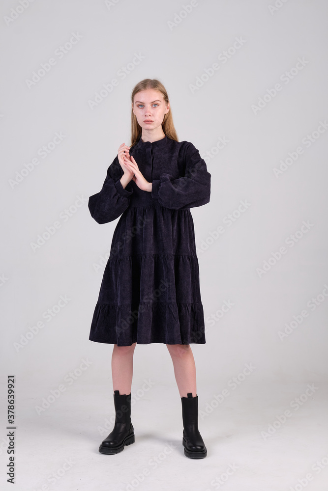 Fashionable handsome woman in casual black dress on white background in studio. Concept of summer clothes fashion catalog shooting. Fashionable handsome woman in casual black dress on white background in studio. Concept of summer clothes fashion catalog shooting.