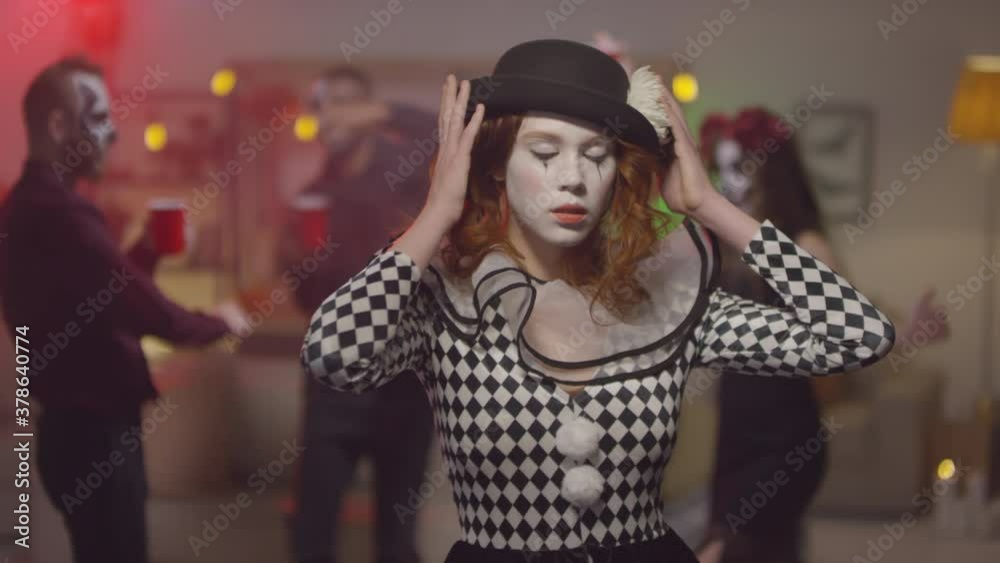 Portrait of beautiful young woman in clown halloween costume posing for ...