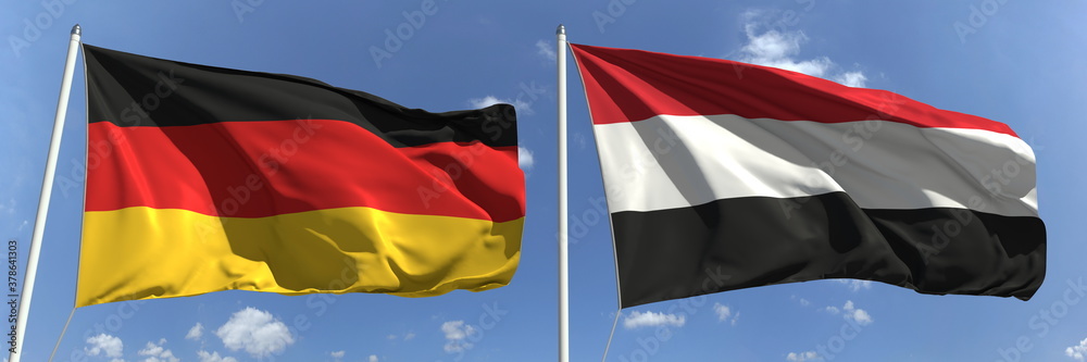 Naklejka premium Waving flags of Germany and Yemen on flagpoles, 3d rendering