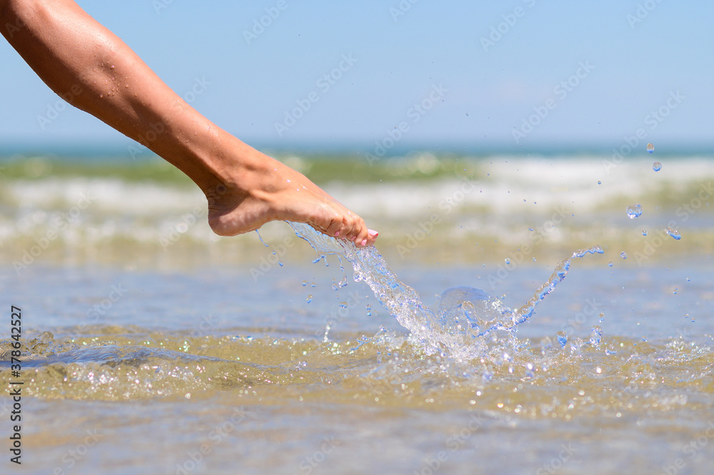 Girl's leg in sea spray. Splashes of clear sea water.