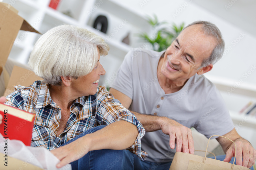 mature couple posing with moving boxes