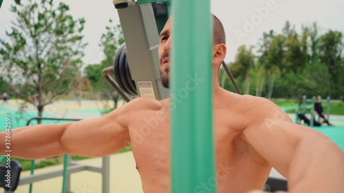 Saint Petersburg, Russia, Yuzhnaya Doroga street, August 21, 2020. Athletic man has a beautiful body, trains on the Playground in the summer on the street. photo