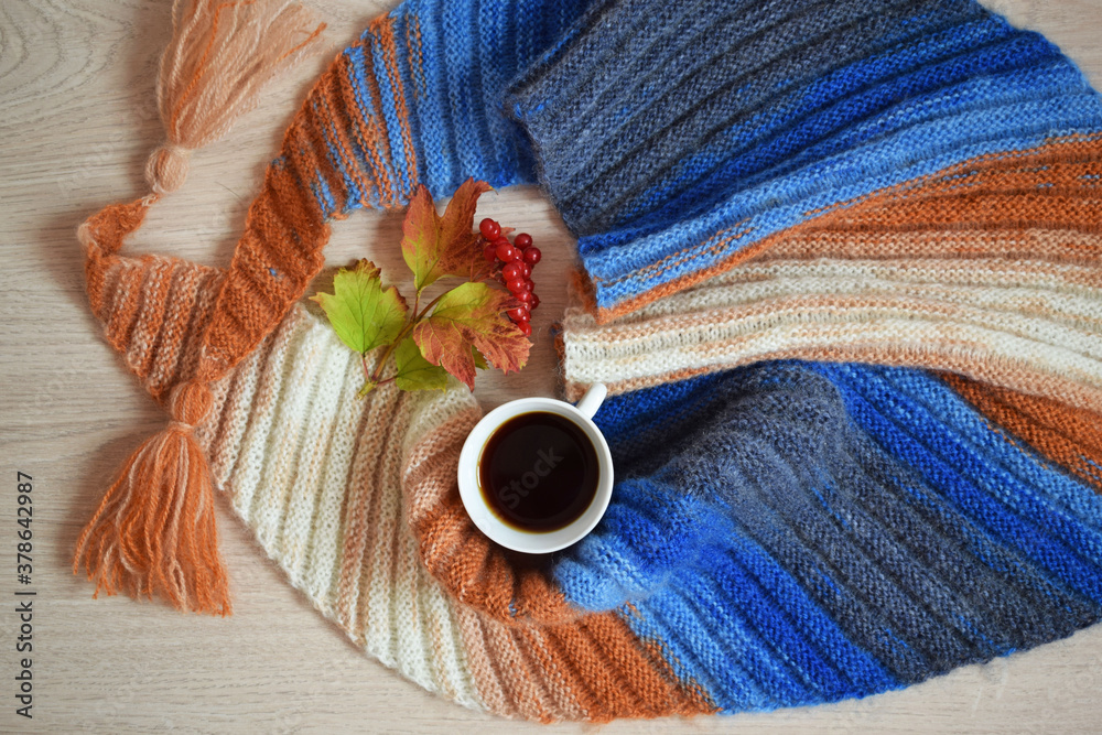 A Cup of fragrant tea and a warm scarf on a gray background. A Cup of fragrant tea and a warm scarf on a gray background.