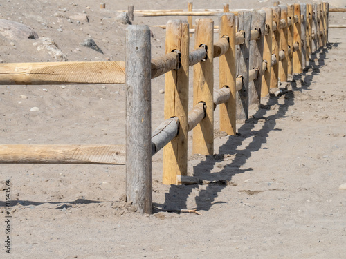 a wooden log fence like a corral on a beach sand dune