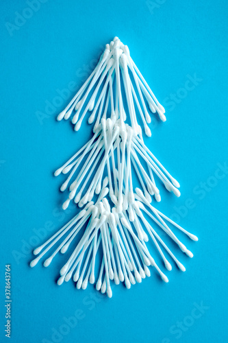 Cotton ear swabs sticks on blue background. close up. Image with selective focus  noise effect and toning. Top view. Flat lay.