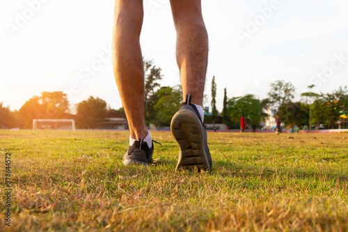 Young man exercise in grass field with sunlight