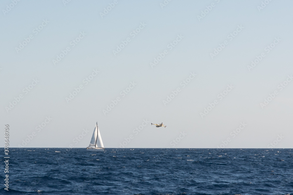 view of propeller firefighters plane flying around a yacht