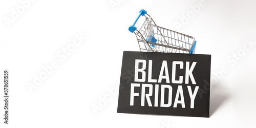 a black signboard with the text black friday written in white, in a shopping cart