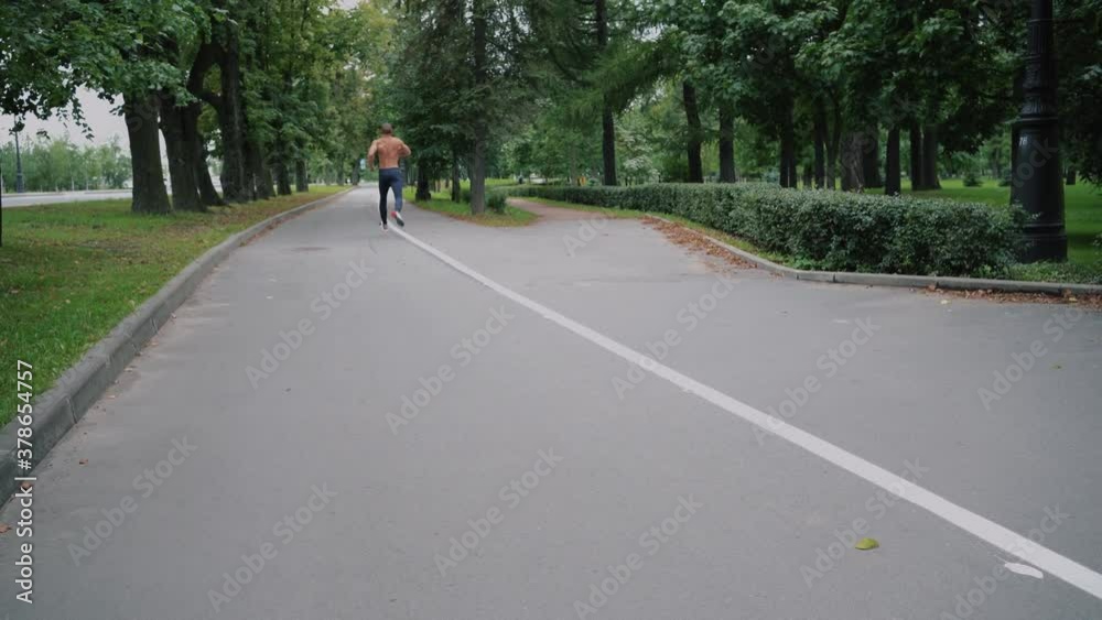 doing a running workout on a treadmill in the Park. bare-chested strong muscles. a man of Caucasian appearance beautiful athletic build doing a running workout on a treadmill in the Park. bare-chested strong muscles. a man of Caucasian appearance beautiful athletic build