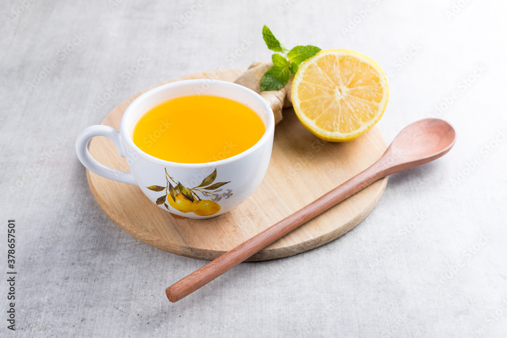 Cup of lemon tea with ginger. On a white wooden table Cup of lemon tea with ginger. On a white wooden table