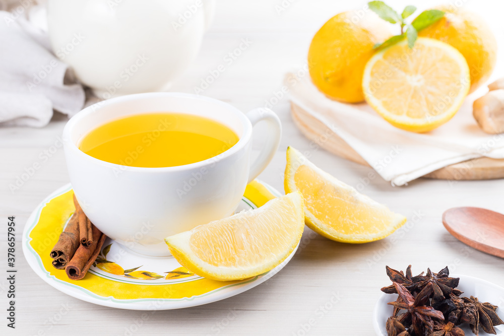 Cup of lemon tea with ginger. On a white wooden table Cup of lemon tea with ginger. On a white wooden table
