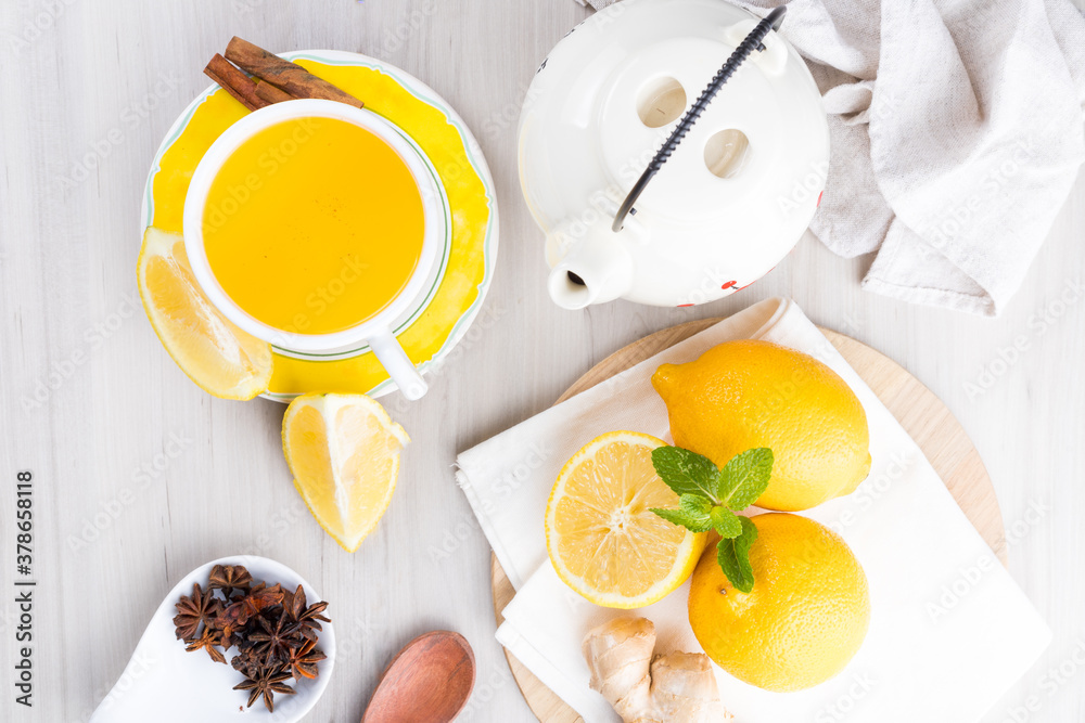 Cup of lemon tea with ginger. On a white wooden table. Top View Cup of lemon tea with ginger. On a white wooden table. Top View