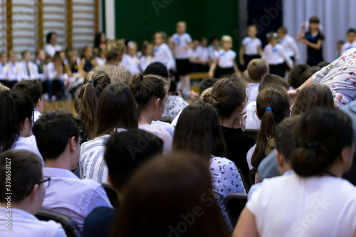 Legionowo, Poland - October 25, 2019: Start of the school year. Students, parents and teachers in the gym during school celebrations. Children in formal clothes, white shirts and dark pants.