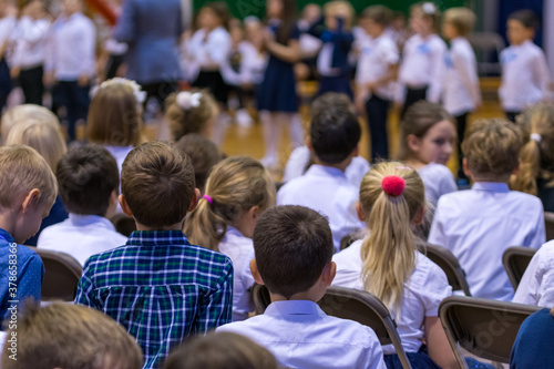 Legionowo, Poland - October 25, 2019: Start of the school year. Students, parents and teachers in the gym during school celebrations. Children in formal clothes, white shirts and dark pants.