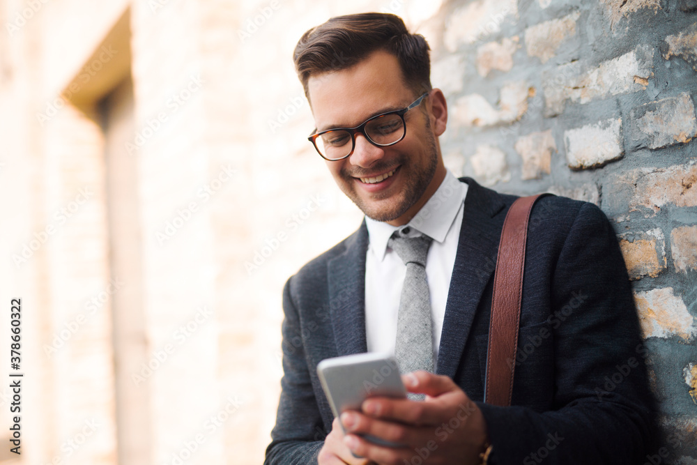 Smiling businessman casually texting Smiling businessman casually texting