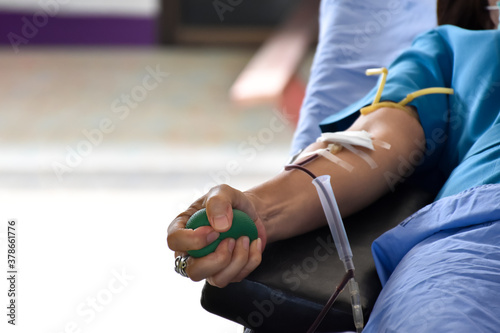 Blood donor at donation area with a green bouncy ball holding in hand.