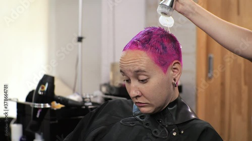 The hairdresser applies the fixing gel to the short haircut. Home salon during the epidemic.