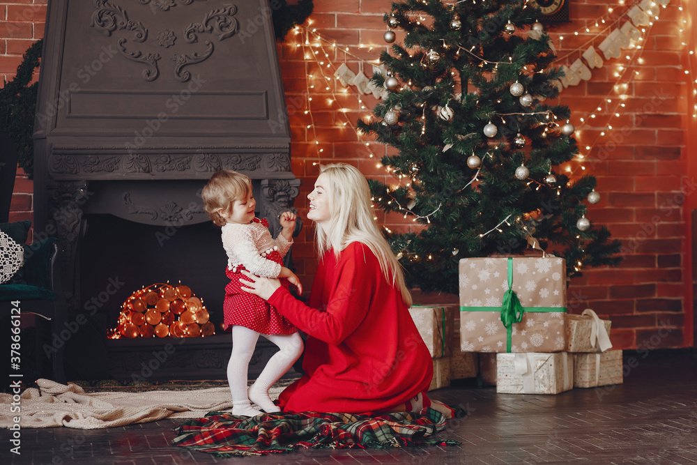 Beautiful mother in a red sweater. Family with cristmas gifts. Little girl near christmas tree Beautiful mother in a red sweater. Family with cristmas gifts. Little girl near christmas tree