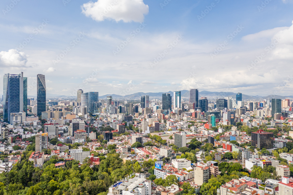 Espectacular vista aérea de la Colonia Roma norte con el skyline del Paseo de la Reforma y un cielo azul como fondo.