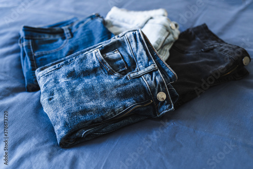 organizing your wardrobe, different jeans in various denim colors getting sorted out photo