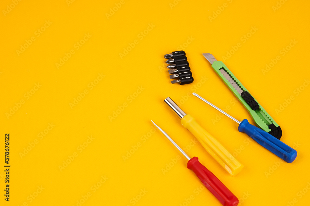 stationery knife screwdrivers and construction tools on yellow background equipment for repair industry stationery knife screwdrivers and construction tools on yellow background equipment for repair industry