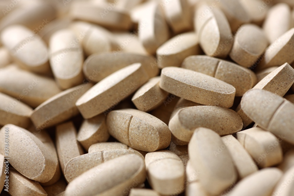Daily vitamins on the white background. Light brown pills isolated on white. Multivitamins. Daily vitamins on the white background. Light brown pills isolated on white. Multivitamins.