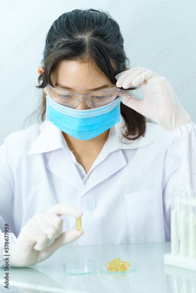 Scientist holding Omega 3 capsule in labcoat Scientist holding Omega 3 capsule in labcoat